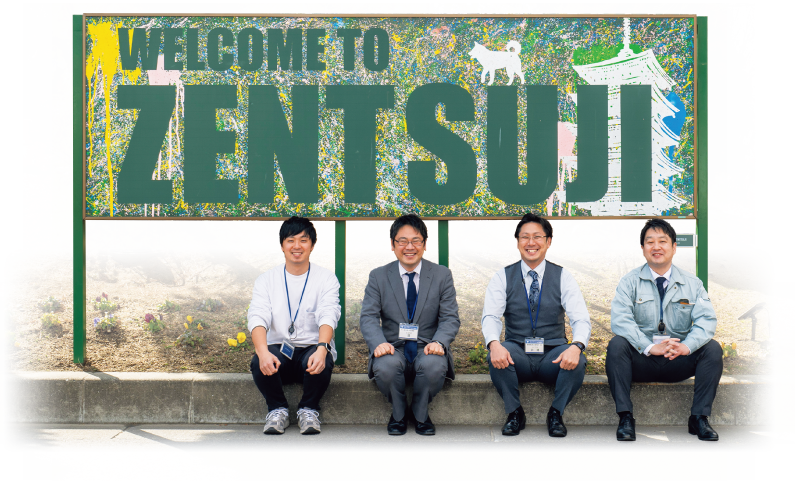 JR善通寺駅前ロータリーに設置された黒板アートの前で、右から秋山さん、井浦さん、環さん、中川さん