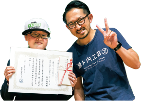 工芸ズの部長 村上モリローさん（右）とグランプリを受賞した實川愛理（じつかわ あいり）さん。帽子はグランプリ受賞者のみに贈られる副賞