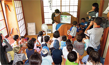 一草庵夏の子どもまつりで山頭火紙芝居を見る子どもたち