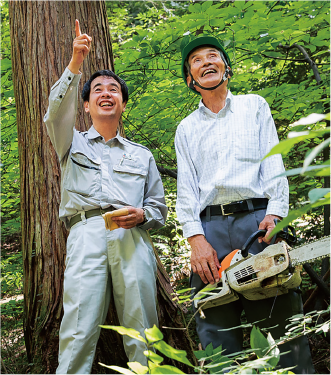 豊田さん（右）の人工林で、ヒノキについて語る菅さん（左）