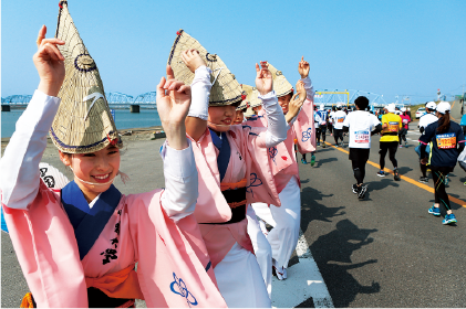 沿道では阿波おどりのさまざまな「連」が熱い踊りでランナーたちを出迎える