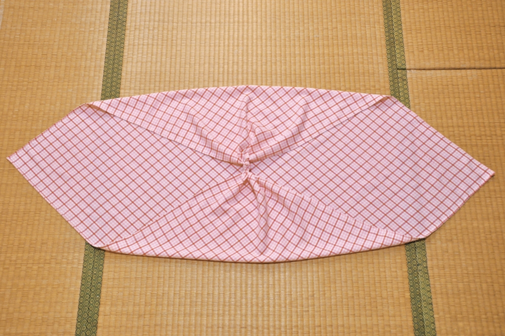 1. 対角を真結びし、結び目を中心に置く。