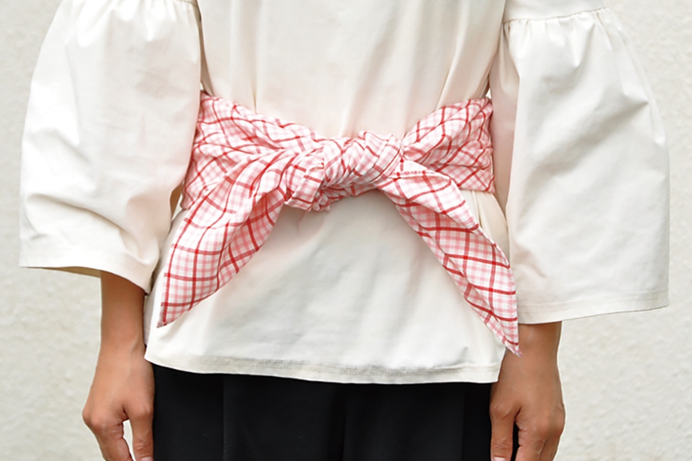 4. 前で真結びをして、結び目を背中に回して完成。