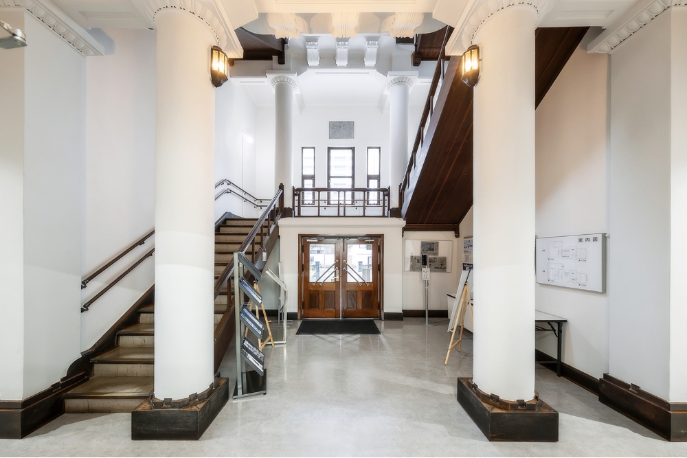 複数の円柱が優雅な雰囲気を醸し出している玄関ホール。階段に使われているリノリウム材も当時ならではの部材