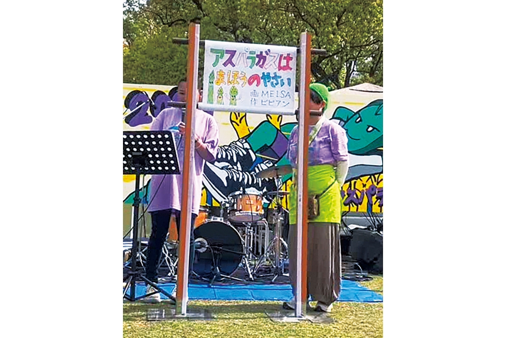 紙芝居師が、アスパラガス農家をテーマにした紙芝居を上演