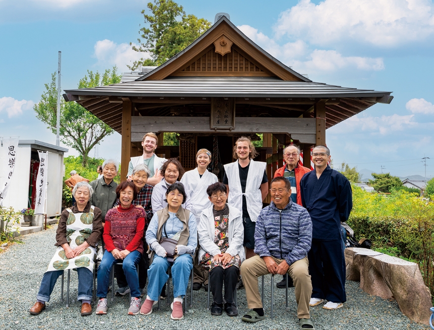 松本大師堂をバックに、松本地区の人たちとお遍路さん。「こんな風に撮った記念写真が私たちの宝物なんです」と代表の依光さん（前列右から2人目）